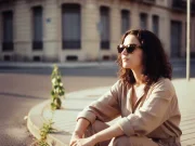 Anna sitzt bei Sonnenuntergang auf einem Gehweg.